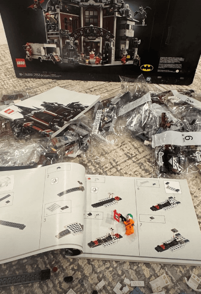 A LEGO Marvel and Batman build spread out with instruction booklet and pieces